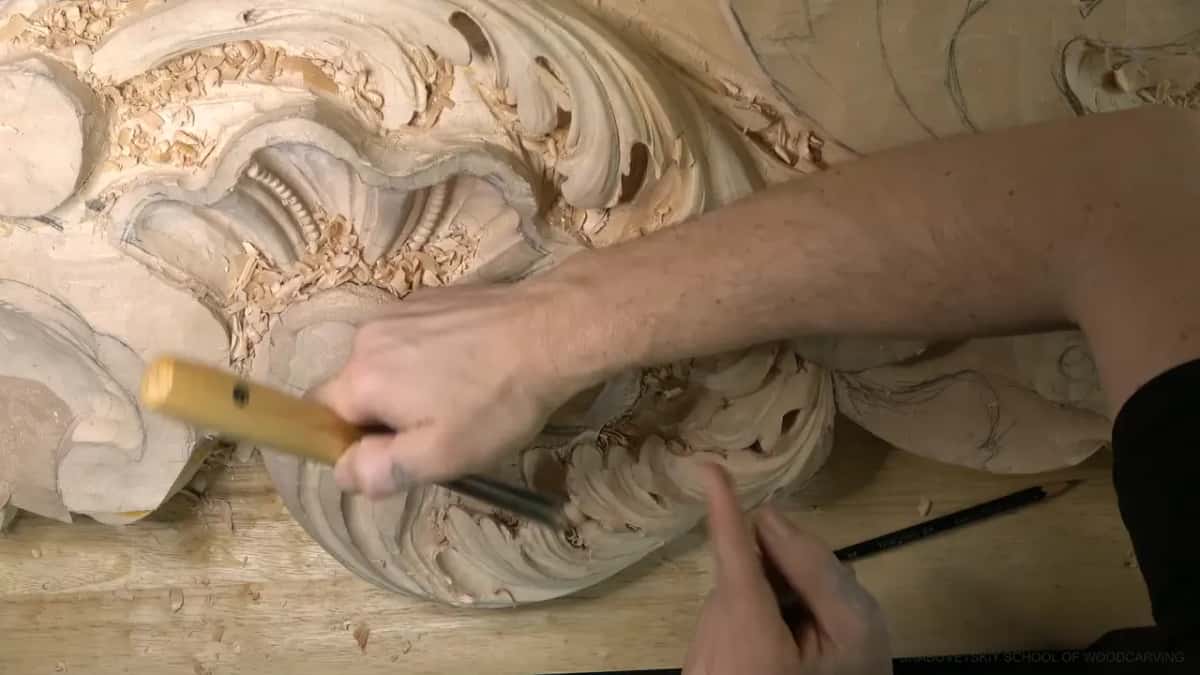 Yellow handle angled across the lobe, the other hand just below.