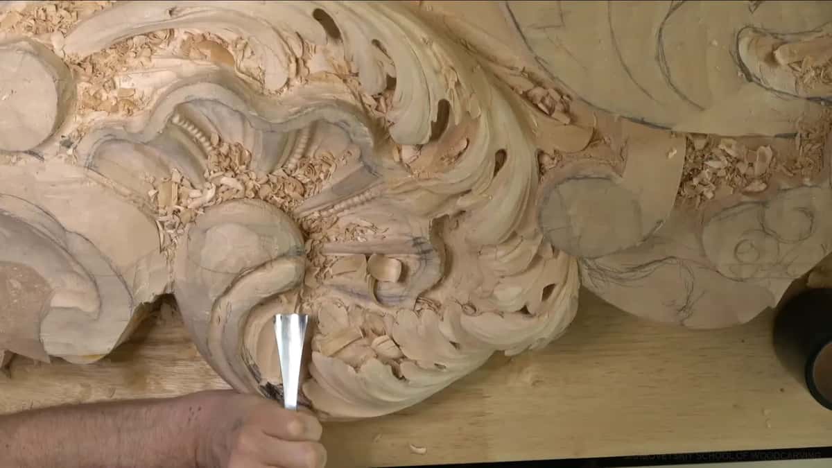 Overhead, one hand aims a gouge up into the head.