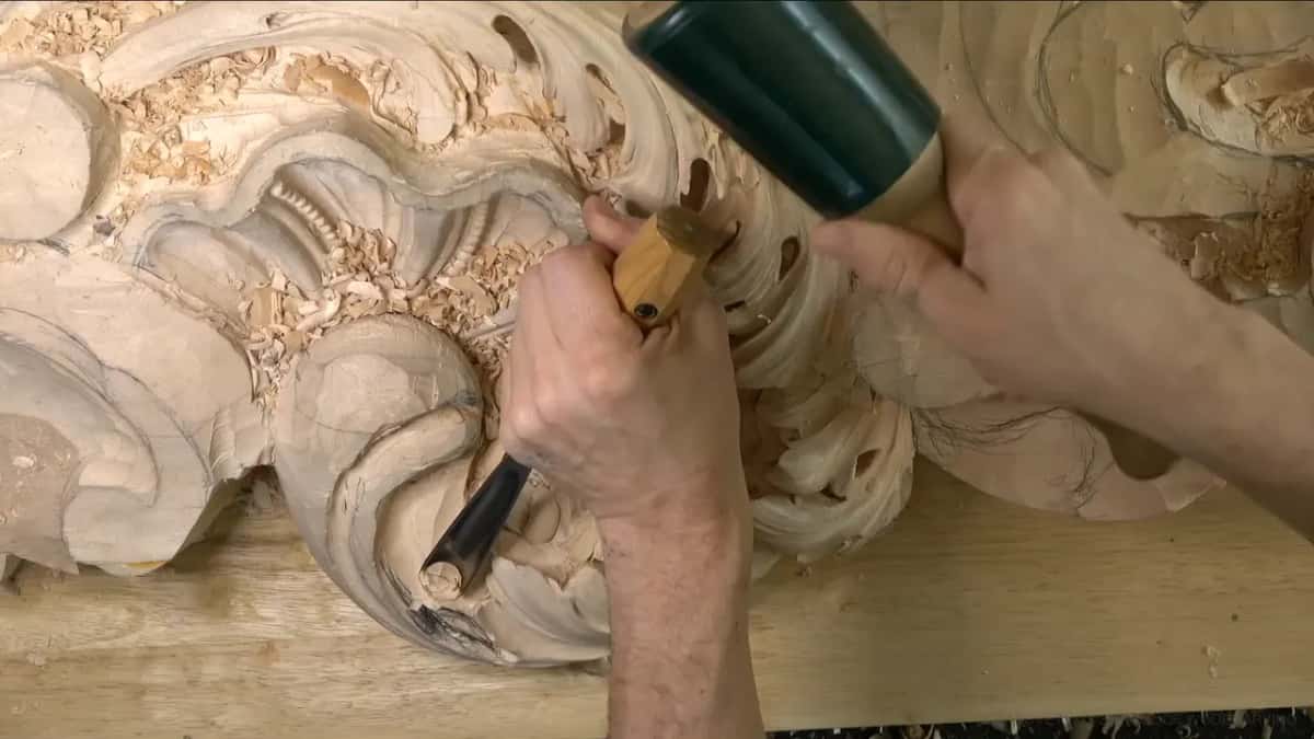 Mallet raised over a gouge.