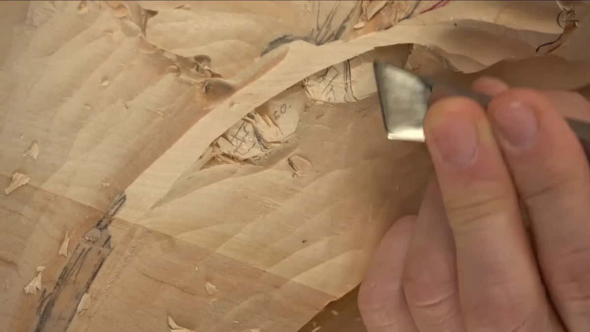 Flat blade tilted at the line of the cap on an acorn marked 60 in pencil