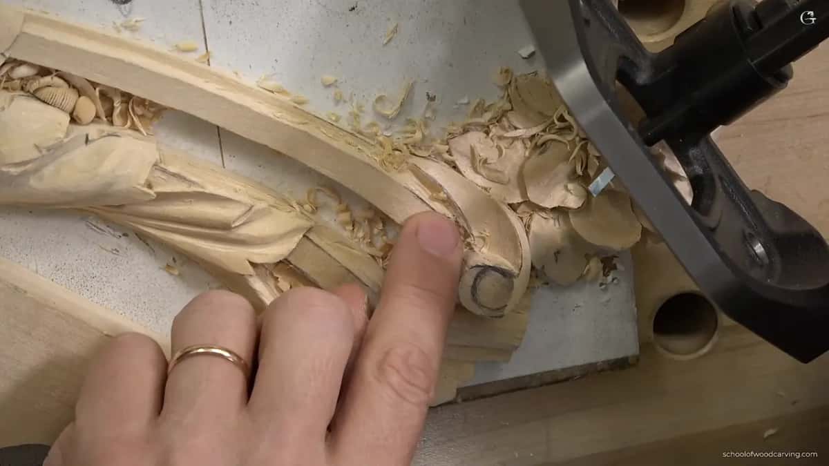 Router plane sitting beside the carving, ready to take the molding ground to depth.