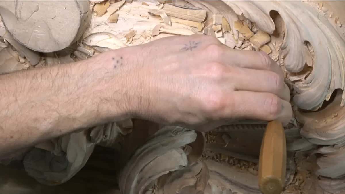 An arm stretched across the carving, gouge on the lower rim.