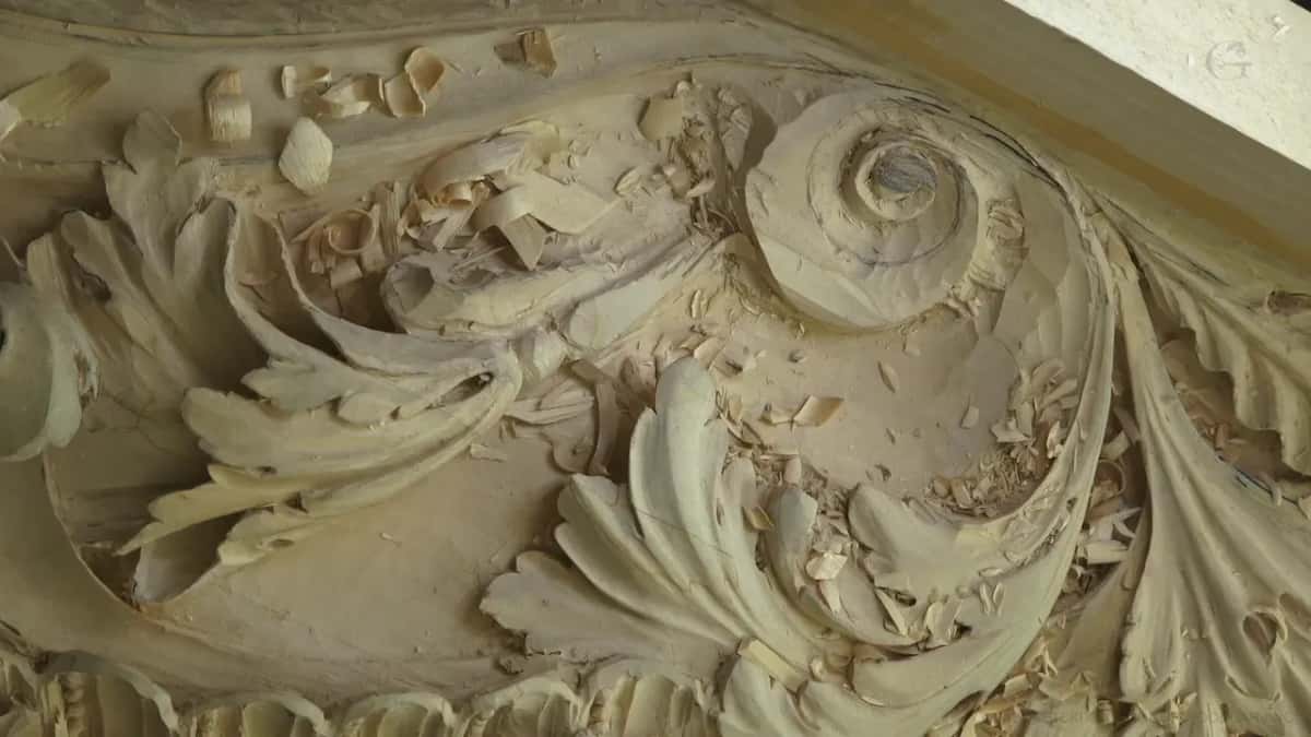 Wide architectural acanthus panel half carved, chips still lying in the hollows and raking light down the scrolls