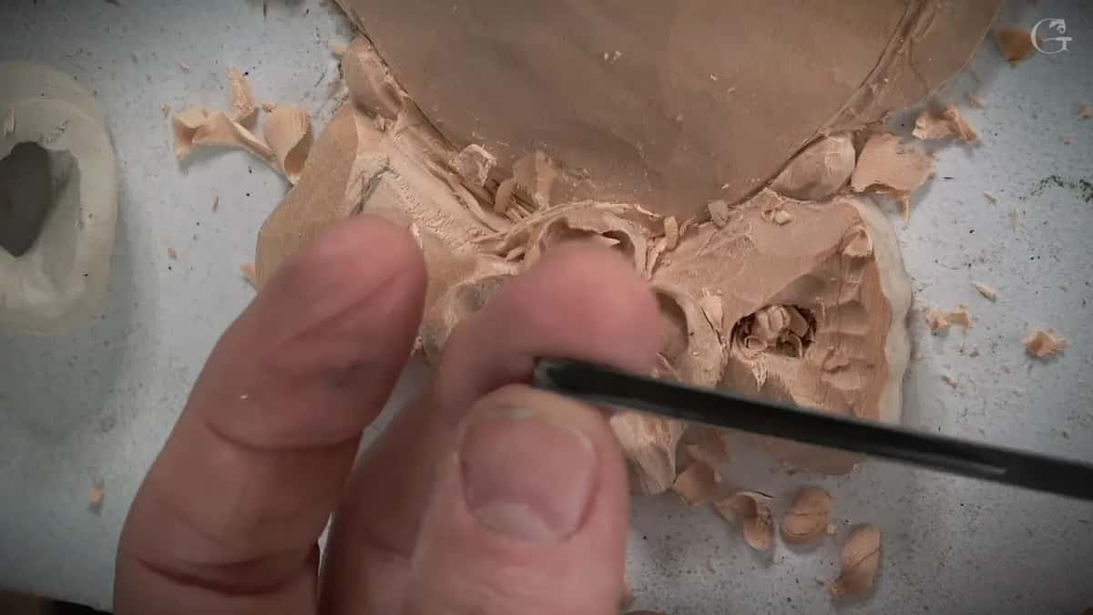 Two fingers steadying a slim blade