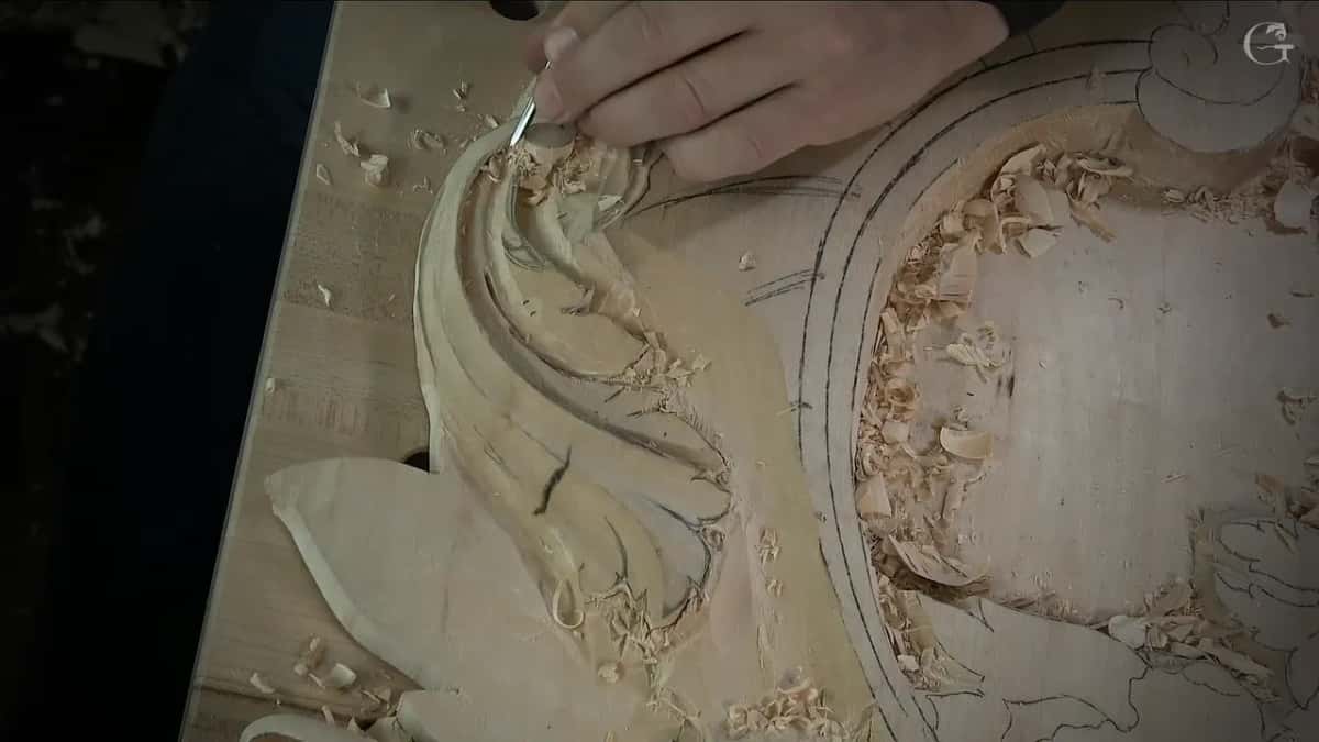 Right hand holding a small tool at the top of the leaf, with shavings all over the hollow beside it