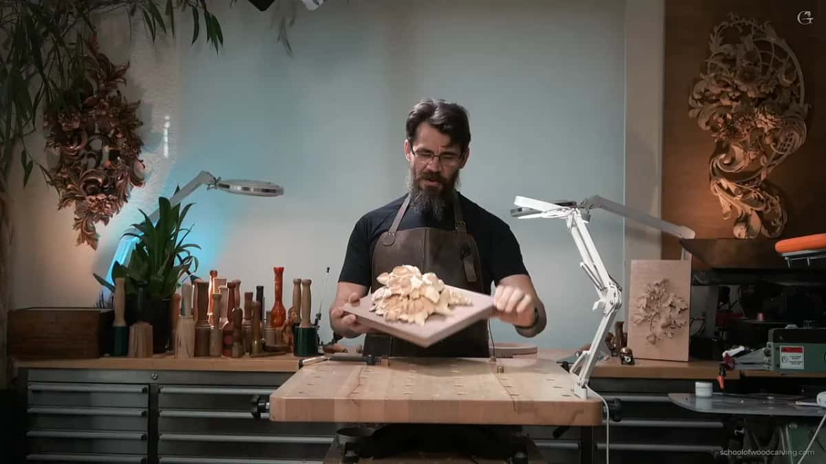 Holding up the carving on its new walnut board so the camera can see the darker ground