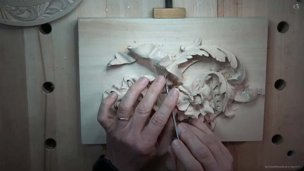 Close view of the carved relief, leaves and a shell cut deep enough to throw shadow.