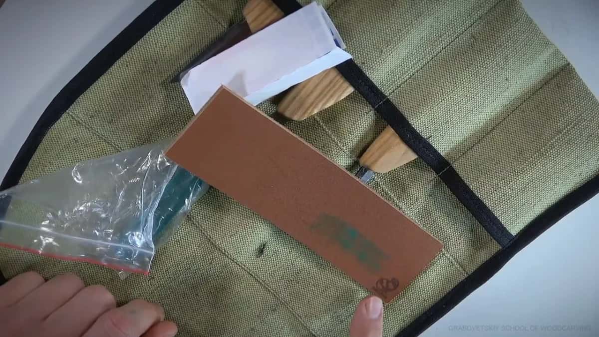 Thick hide strop beside a bag of green compound, both packed in with the tools rather than sold on.