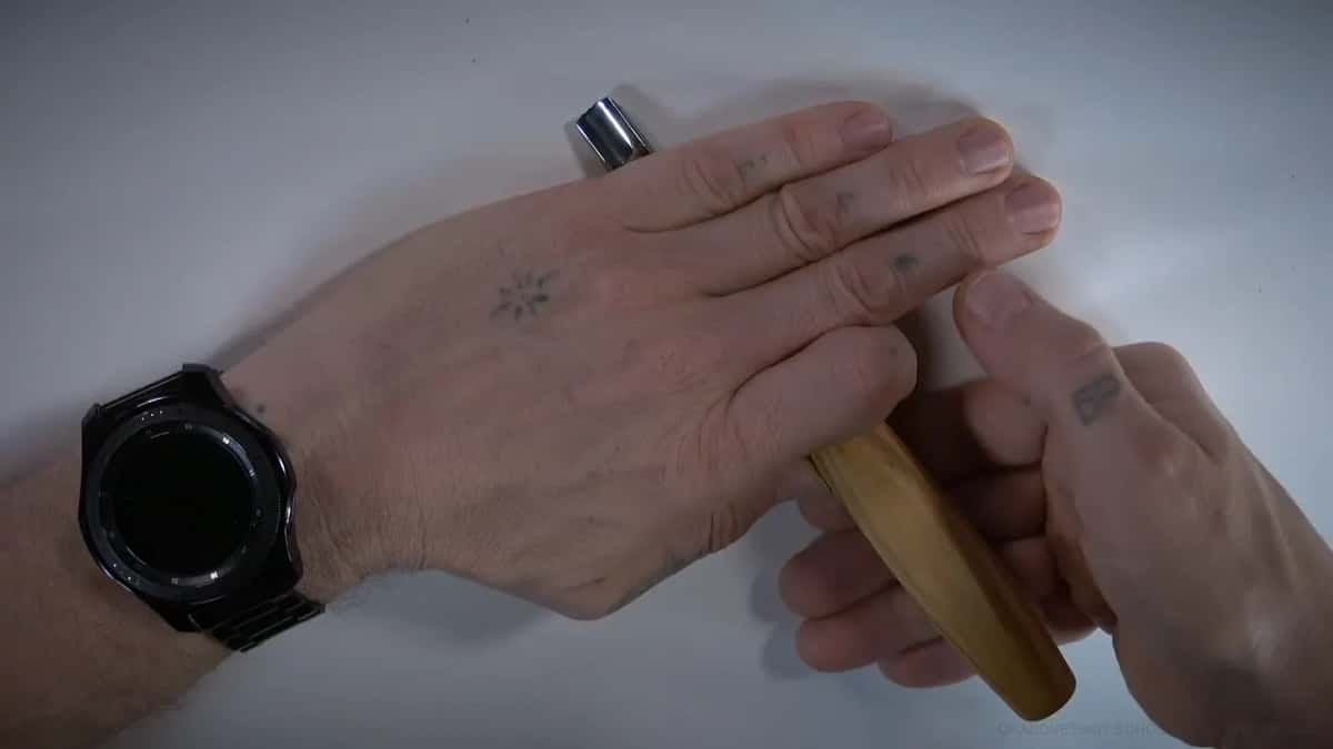 Both hands closed around the handle, palm sitting on the notch he likes.
