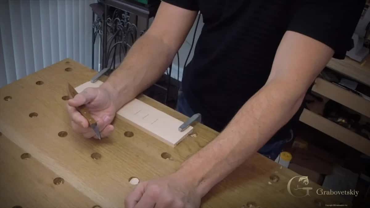 Standing over the board with the knife in hand