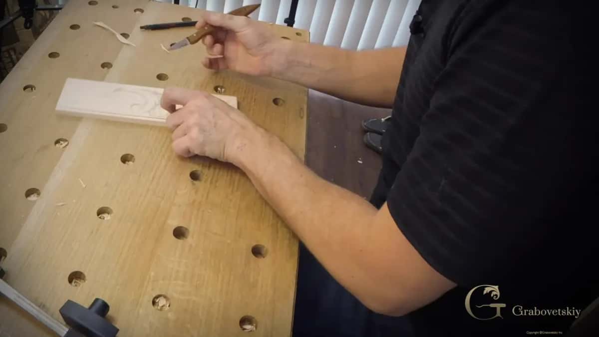 Point down on the board, the other hand steadying it there while the cut runs