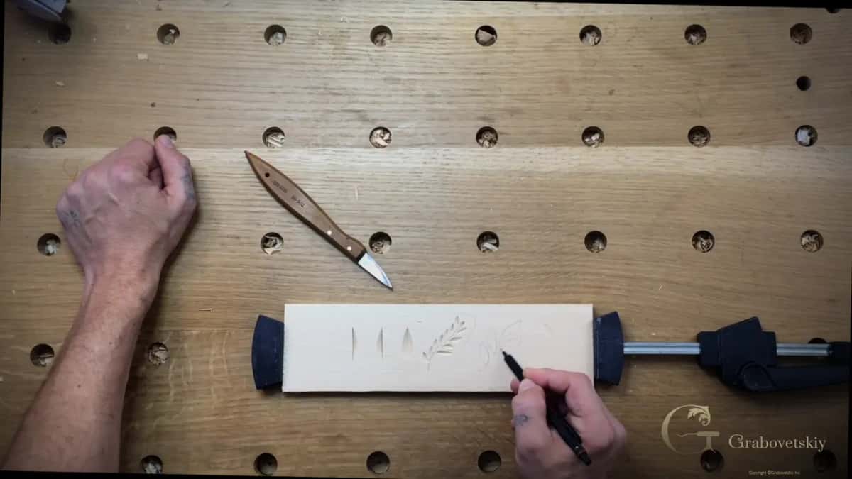 Deliberately oversized leaves drawn on the clamped board, the knife lying ready beside them