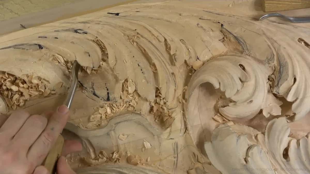 Deep in a chip-filled pocket, a bent gouge works with both hands on it.