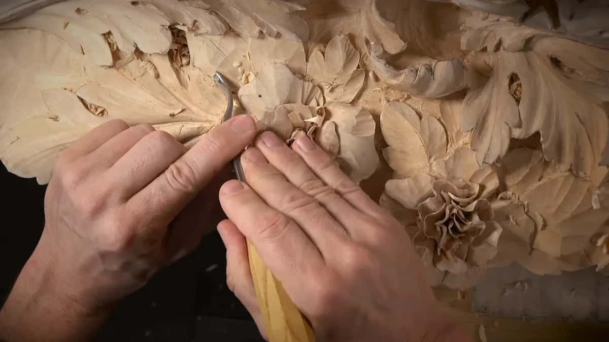 Two hands guide a bent gouge