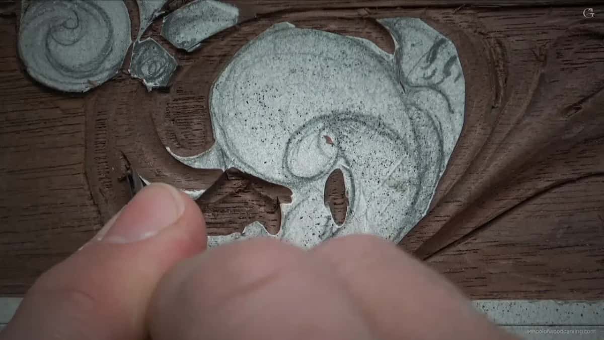 Two fingertips pinching something barely thicker than a needle, working at the tightest part of the shape.