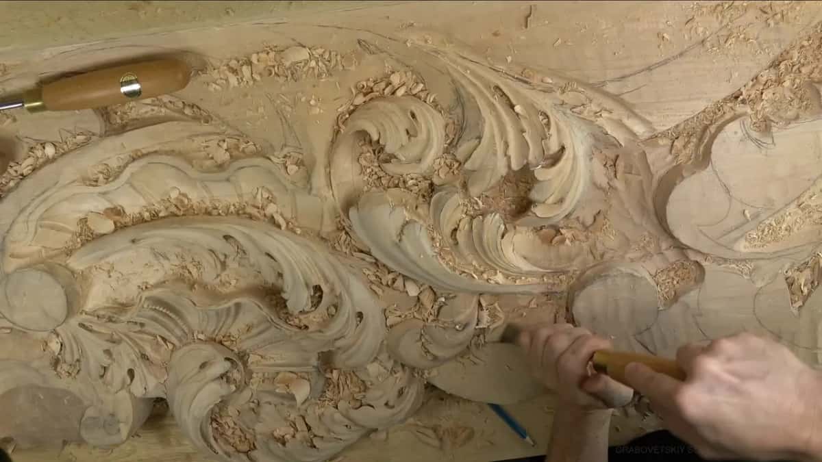 Both hands hold a long handle level along the lower curl.