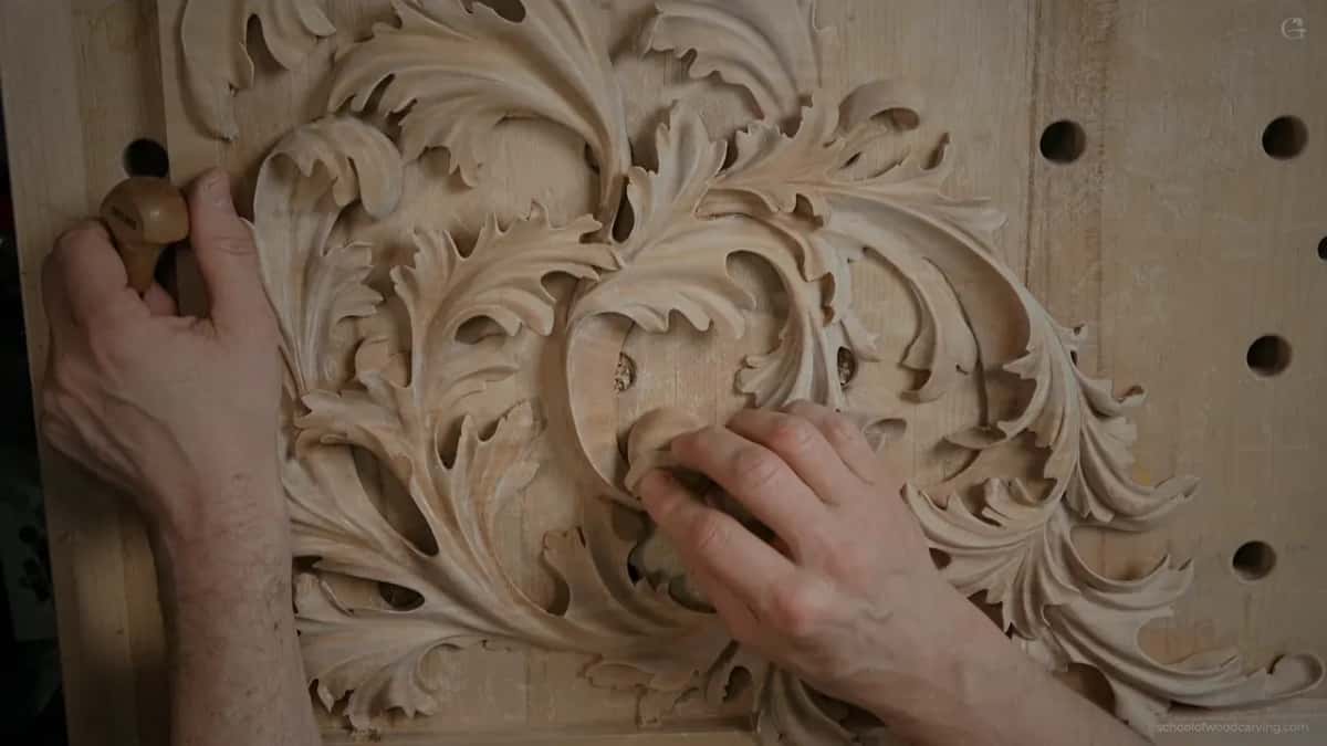 Fingers resting on a leaf of the pipe organ shade, the carving knife held off to one side