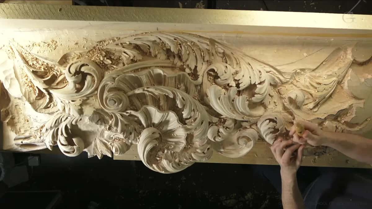 Both hands low on the right side of the panel while a scroll takes shape