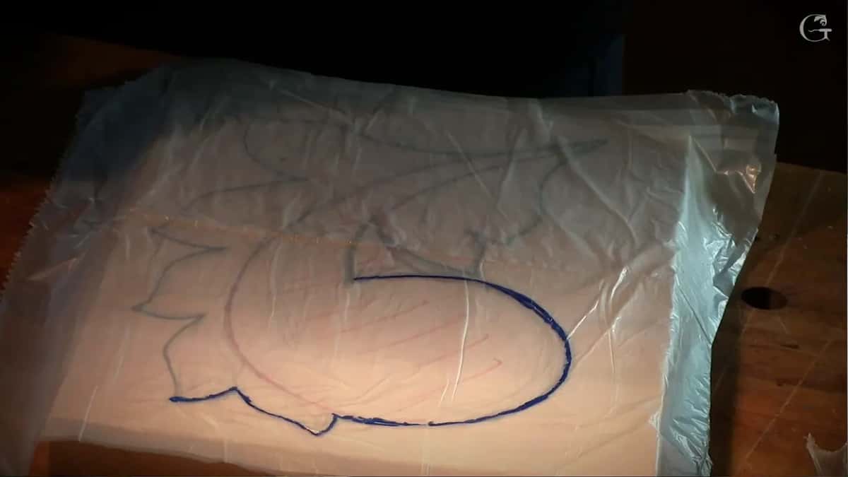 Blue line traced onto the plastic sheet laid over the drawing