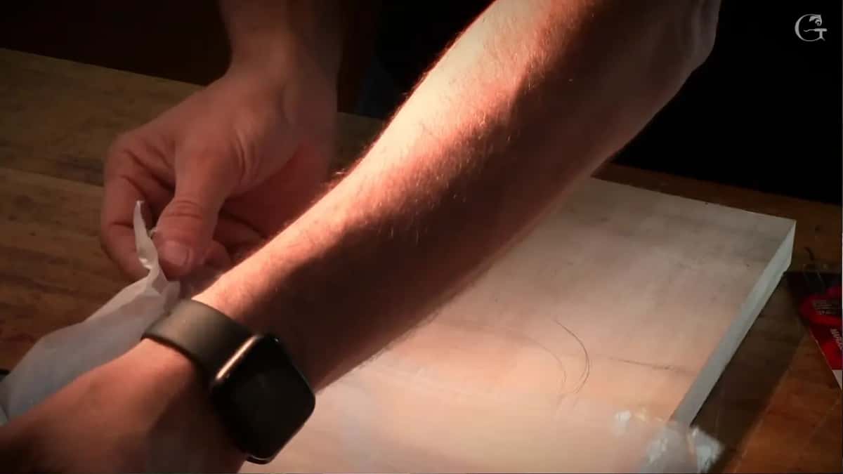 Pulling the plastic sheet across the bench