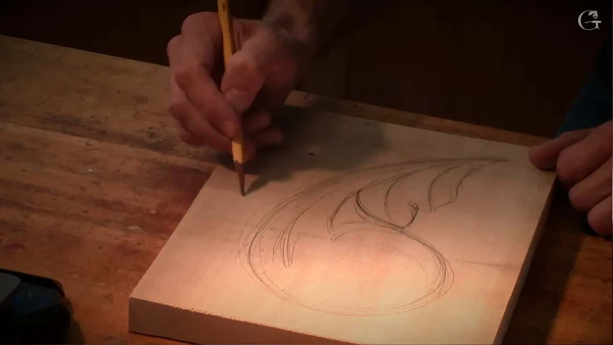 Adding more lines to the design, the pencil working down the far side