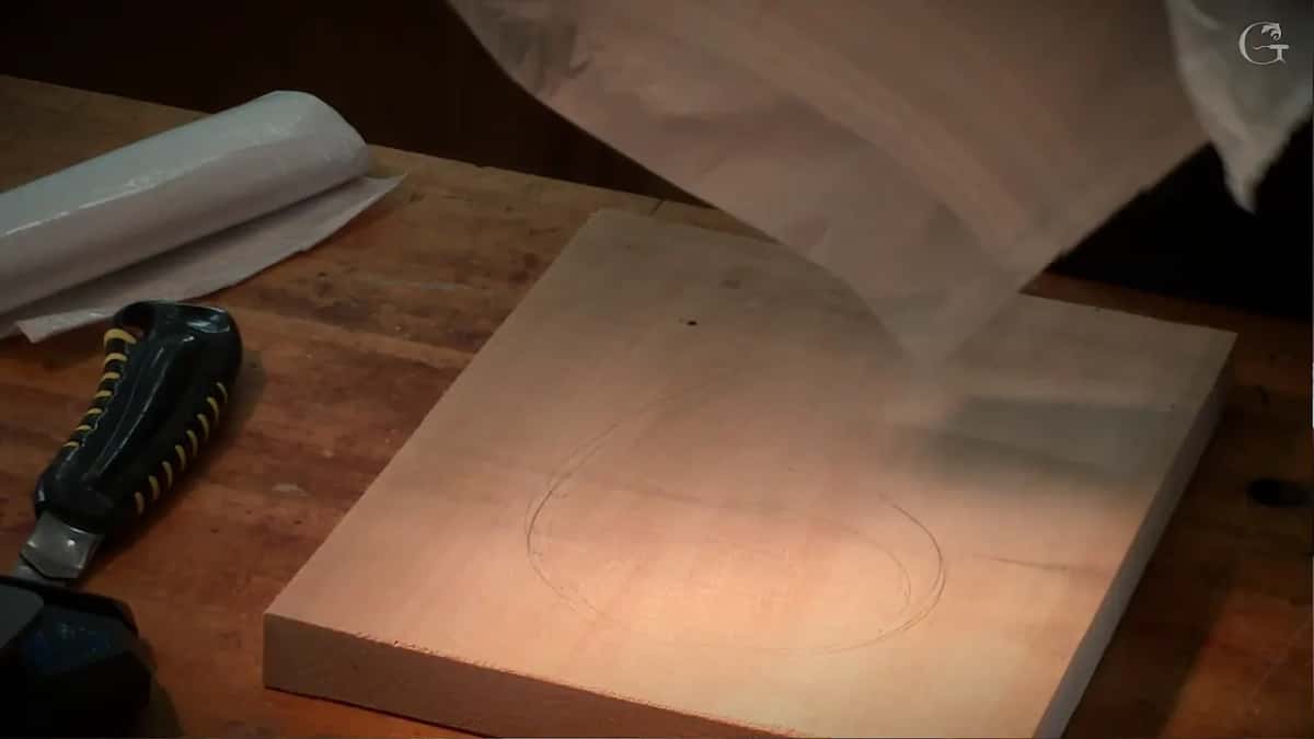 Plastic sheet lifted over the board with a cutter lying beside it