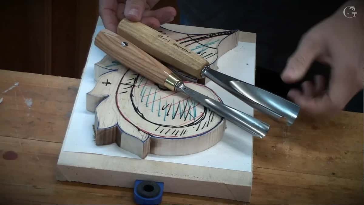Two gouges laid side by side, their sweeps compared against each other on the wood