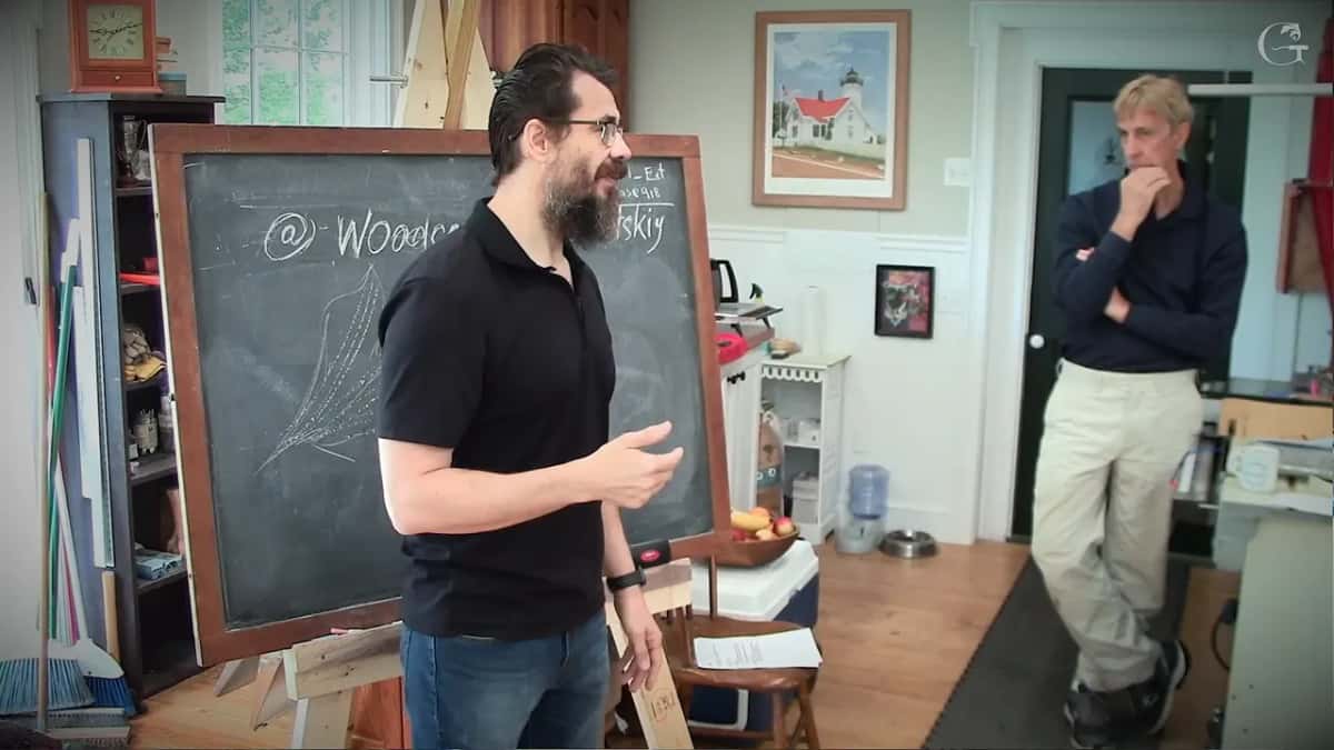 Turned toward the class, hands apart, making the last point of the whole day