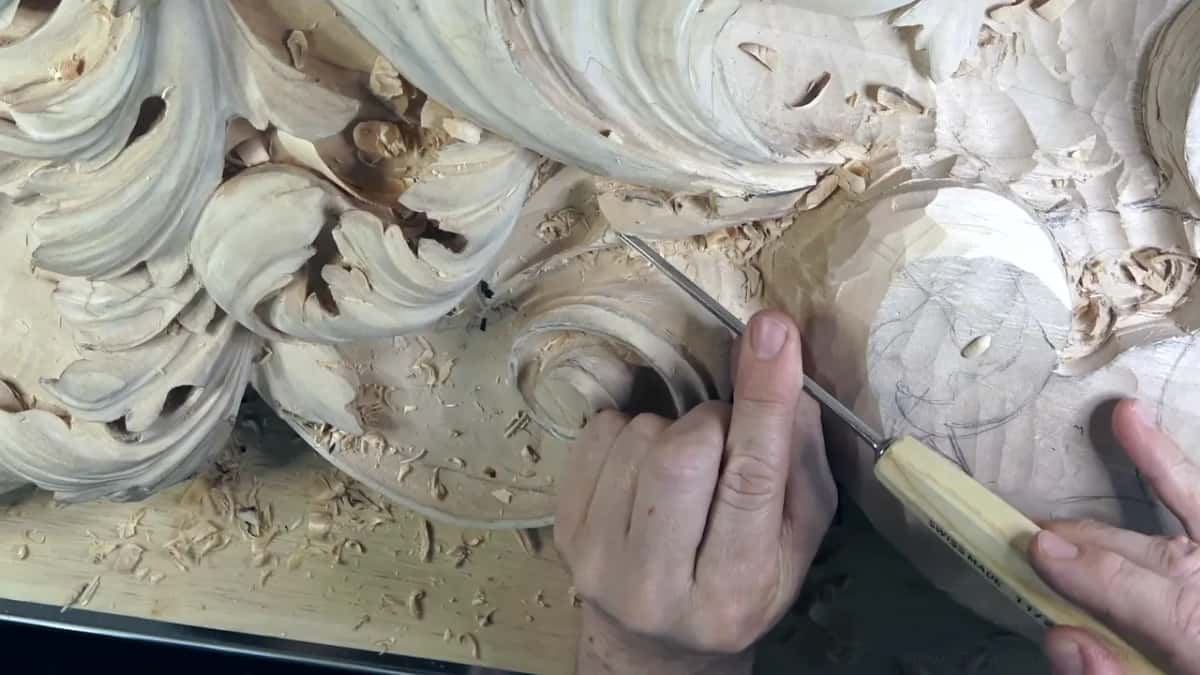 A yellow handled gouge at work in the smooth part, circles of pencil on it.