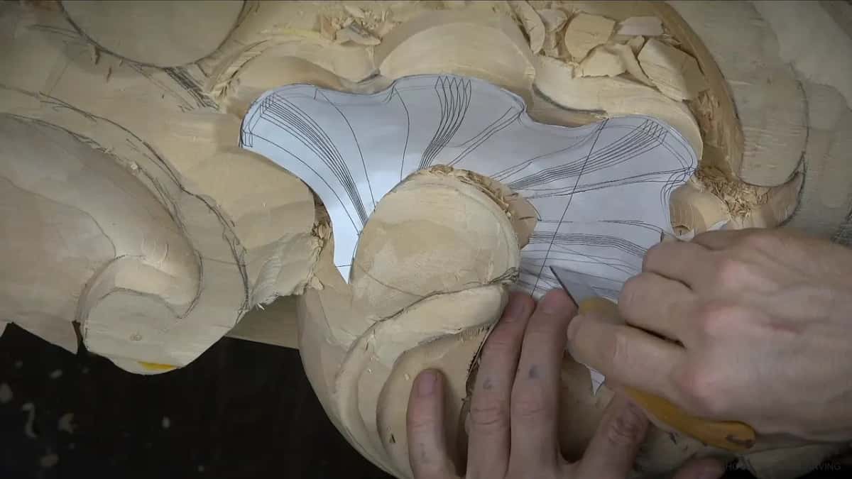 A knife follows the printed lines of a paper pattern laid flat over the shell, pressing through