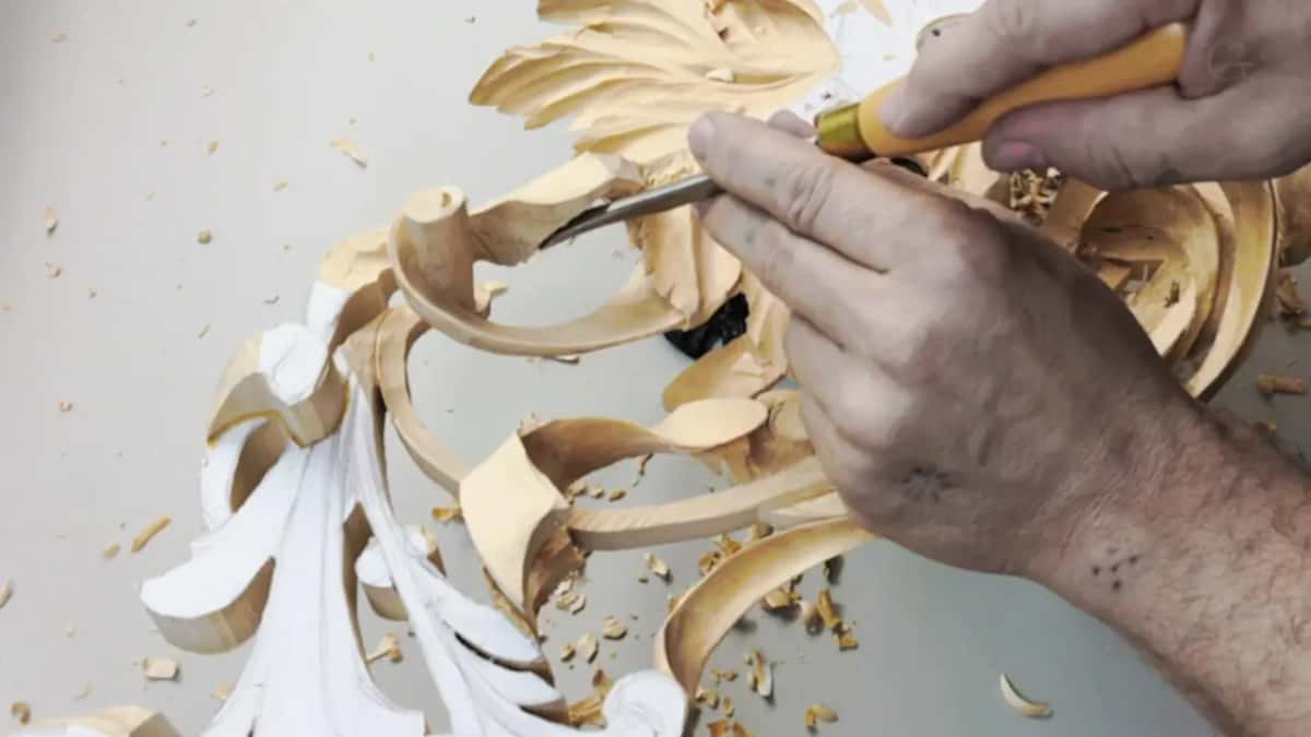 Fingers of one hand on the blade and the other hand on the yellow handle, both close in