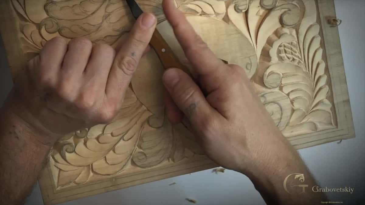 Palm under the blade, two fingers steering.