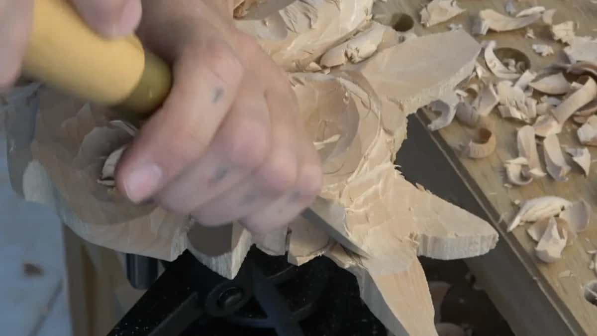 Yellow handled gouge at the edge, thick shavings piled along the bench