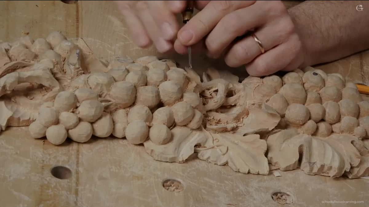 Two hands on a fine tool, both steadying it while the passes get shorter and shorter