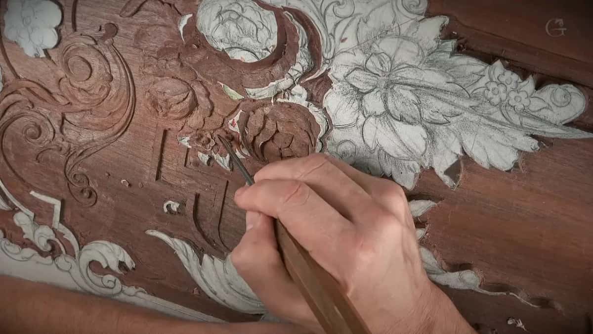 Pale handle gripped in the palm, its steel running up to the carved rose