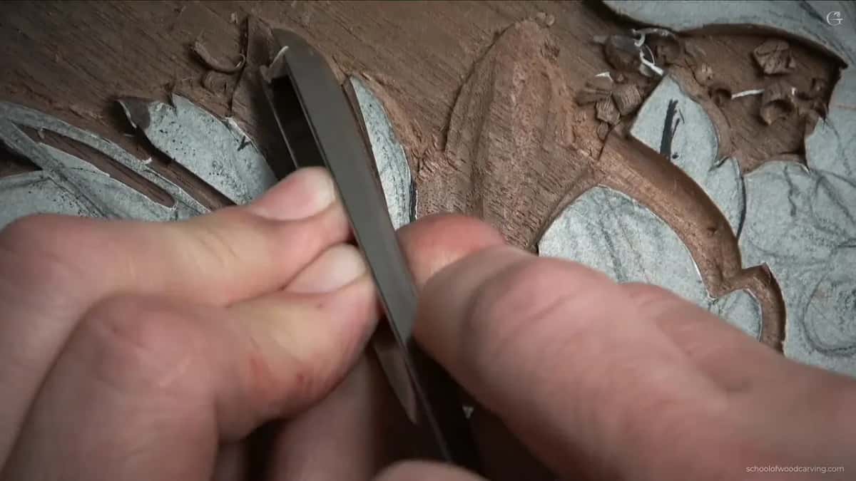 Fingers around a flat blade, working over the opposite side now.