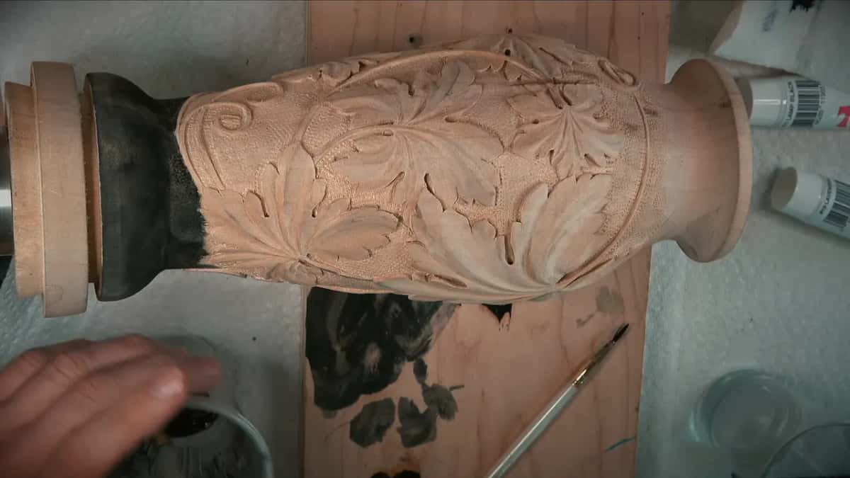 Neck and foot of the vase already painted black, brush and test board below