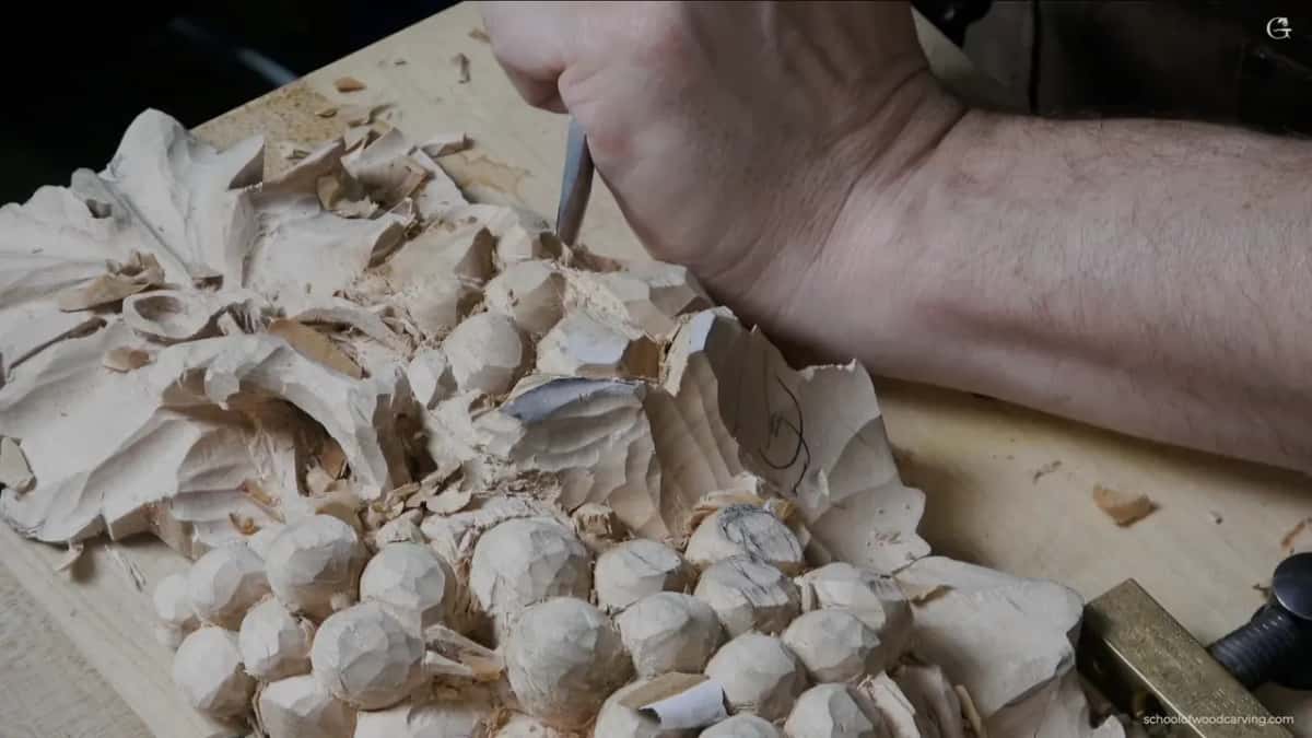 Forearm braced over the work while the shape of the waste decides where the next berry can sit