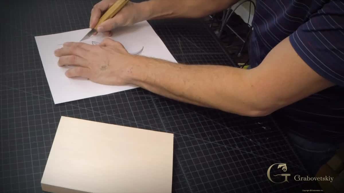 Cutting the paper down to the size of the block on a green mat