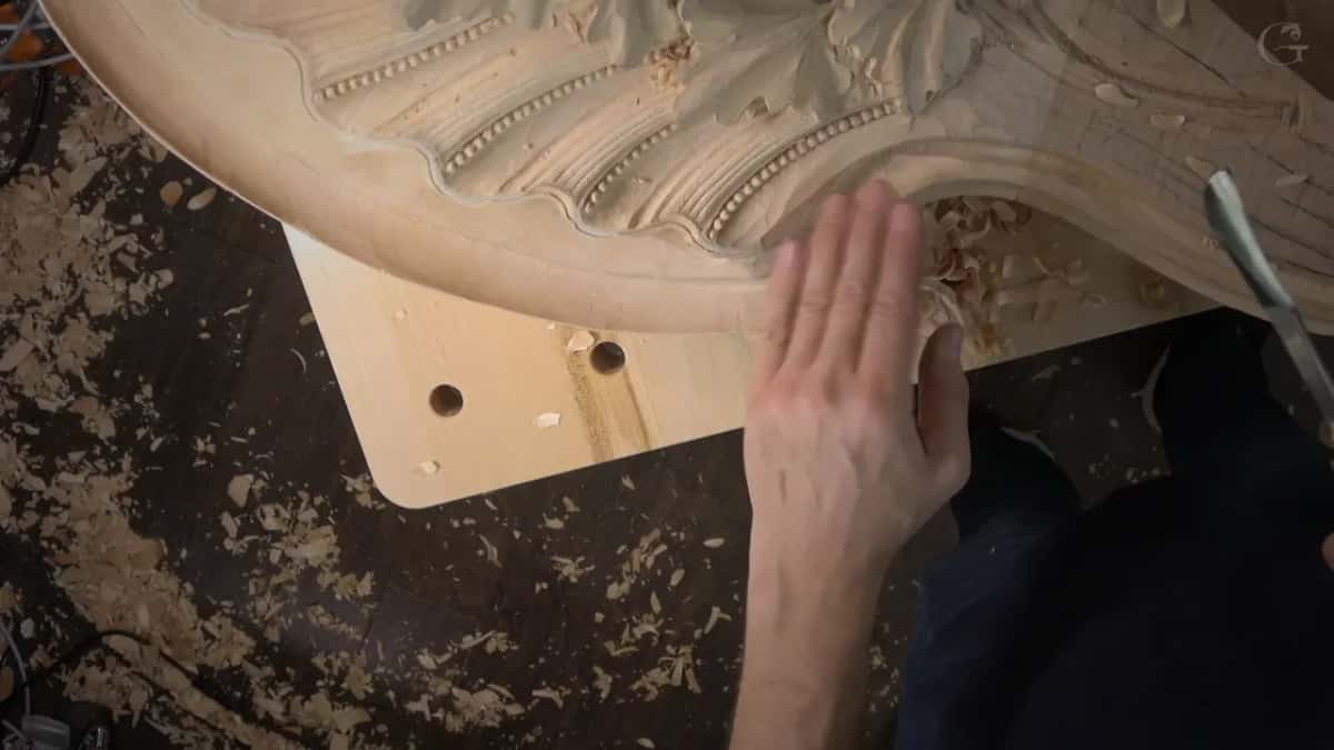 Palm feeling the carved edge for waviness