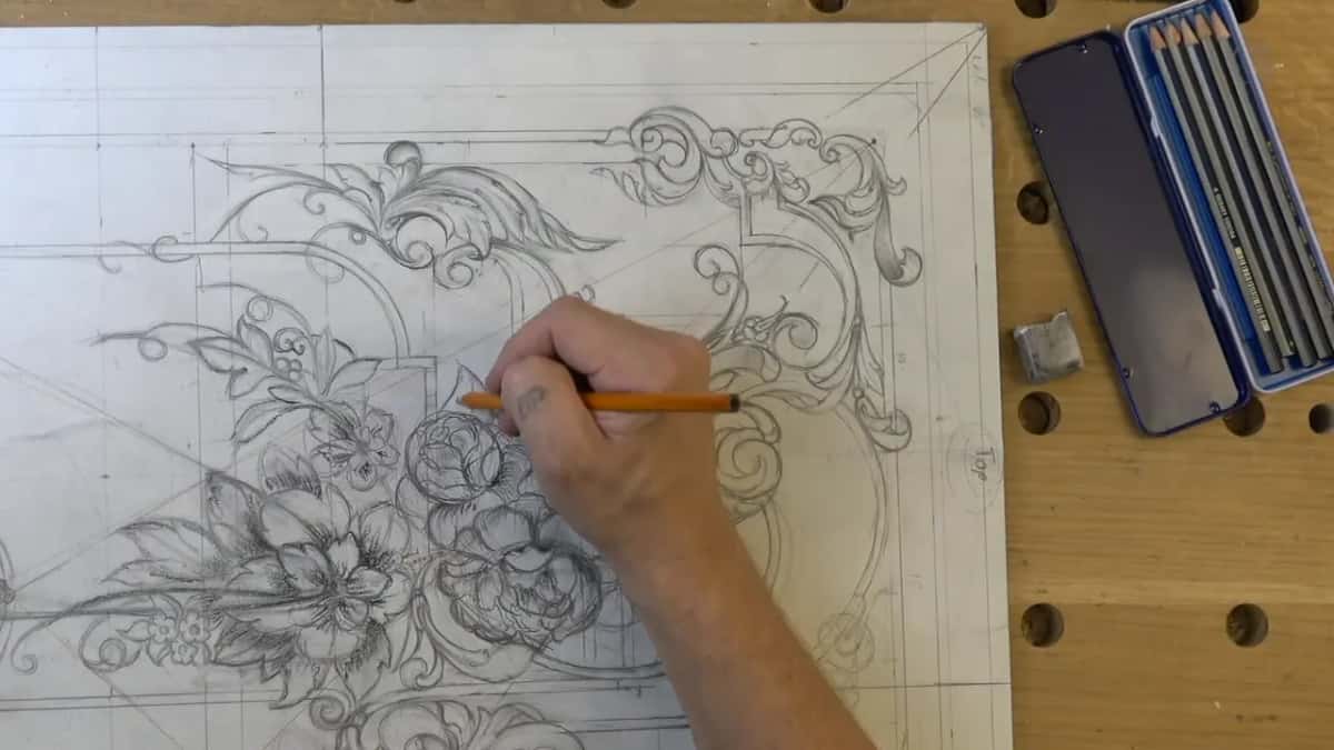 Open tin of pencils and a white eraser sit on the bench at the right while the left hand darkens the gap between two leaves