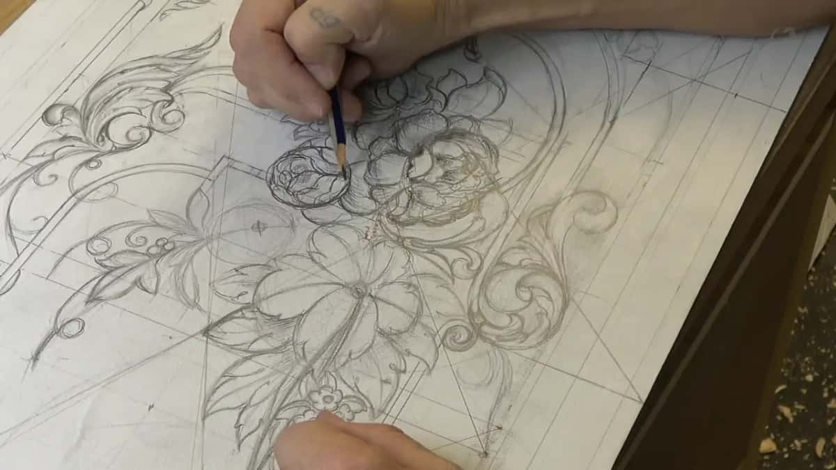 Shadow laid under a flower so the layers separate, the long border scroll still only outlined in light pencil