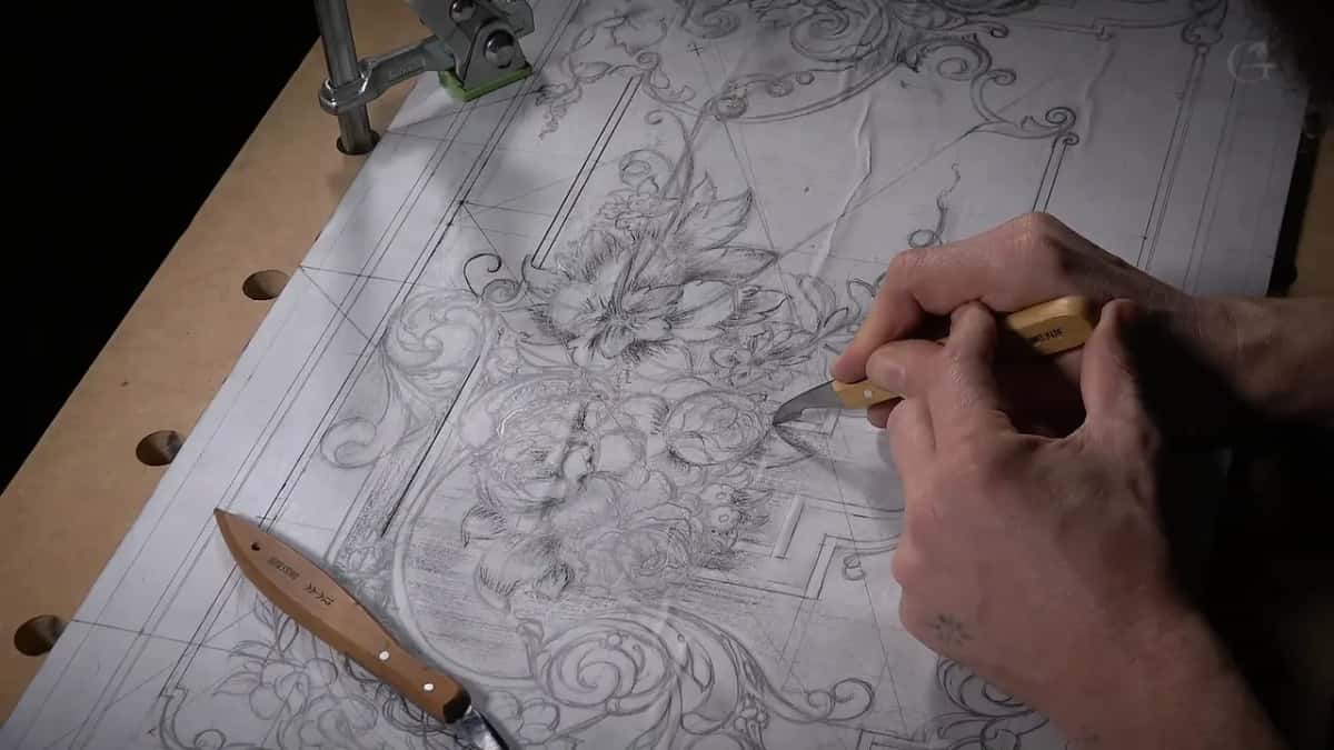 One knife in hand and a second lying along the left edge, the clamp just in shot at the top