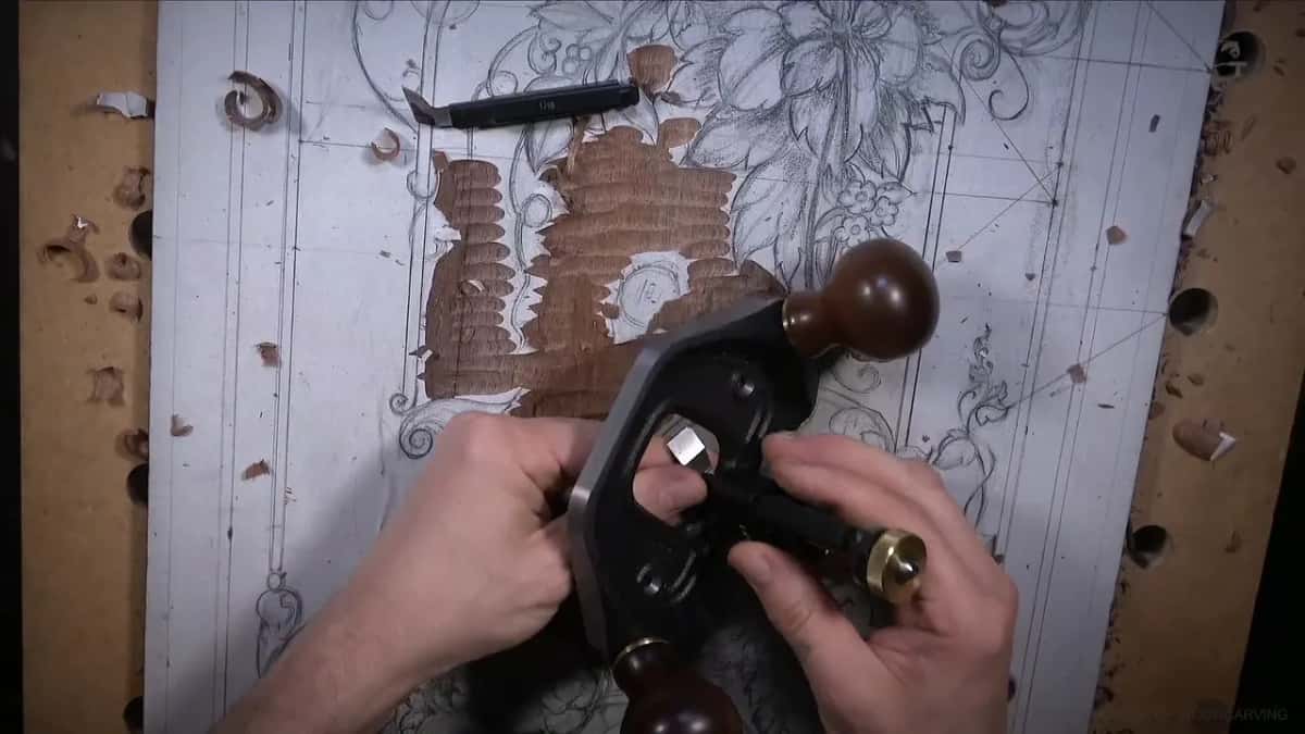 Shavings scattered across the board, both hands on the router plane