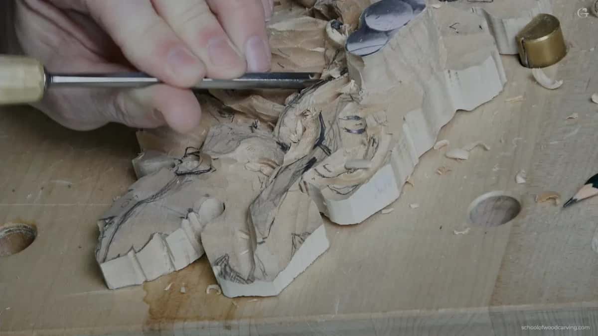 Narrow gouge clearing beside the curl, leaving about a quarter of an inch of room to reach underneath later
