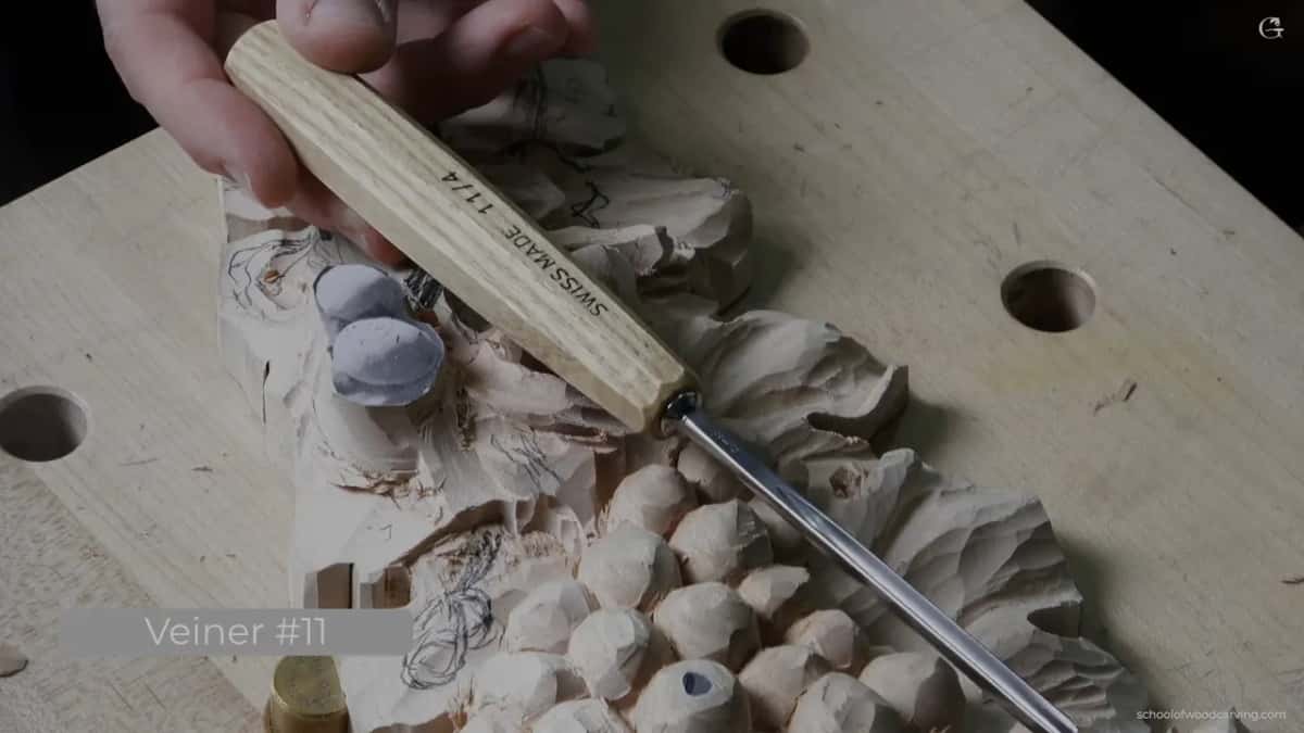 Pale handled veiner held above the work, its number stamped on the screen caption as an 11