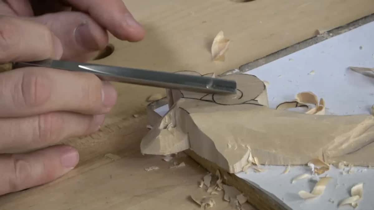 A wide gouge held in both hands, taking one pass across the lowered ground.