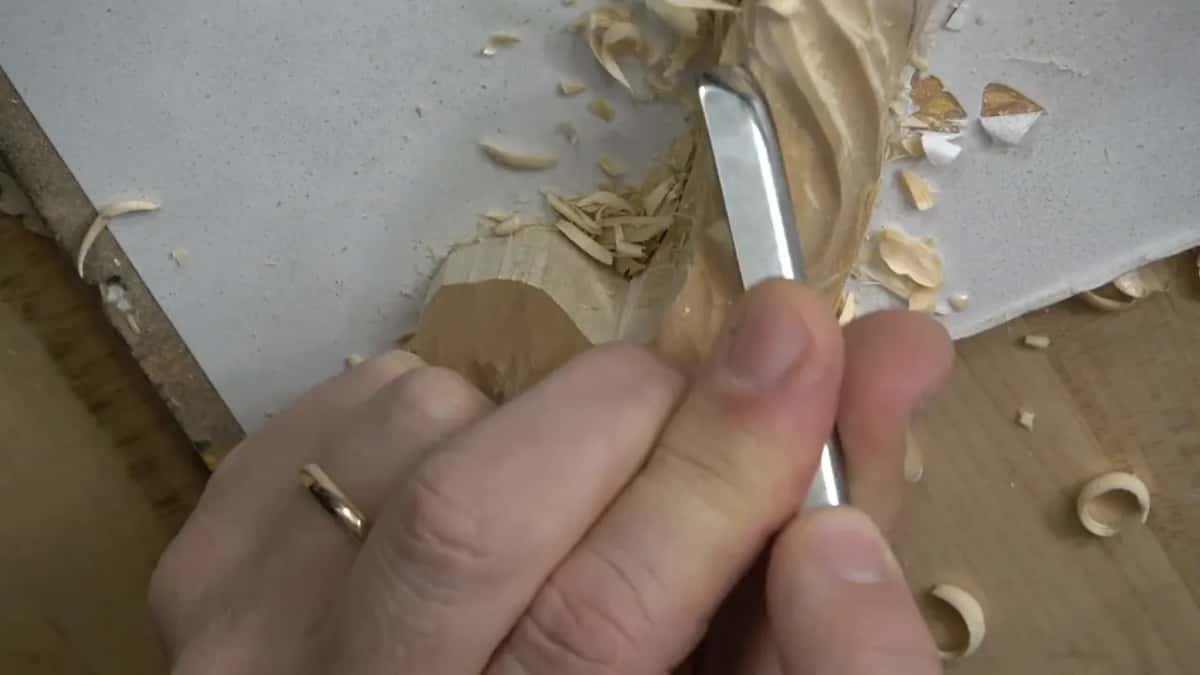 Two hands on one small tool, taking very little at a time along the raised line.