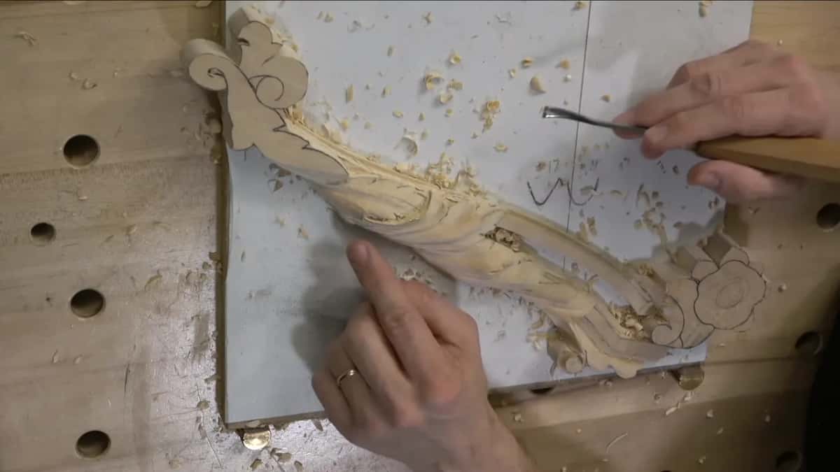 Both hands steady the panel while a pencil in the right hand marks where the next separation falls.