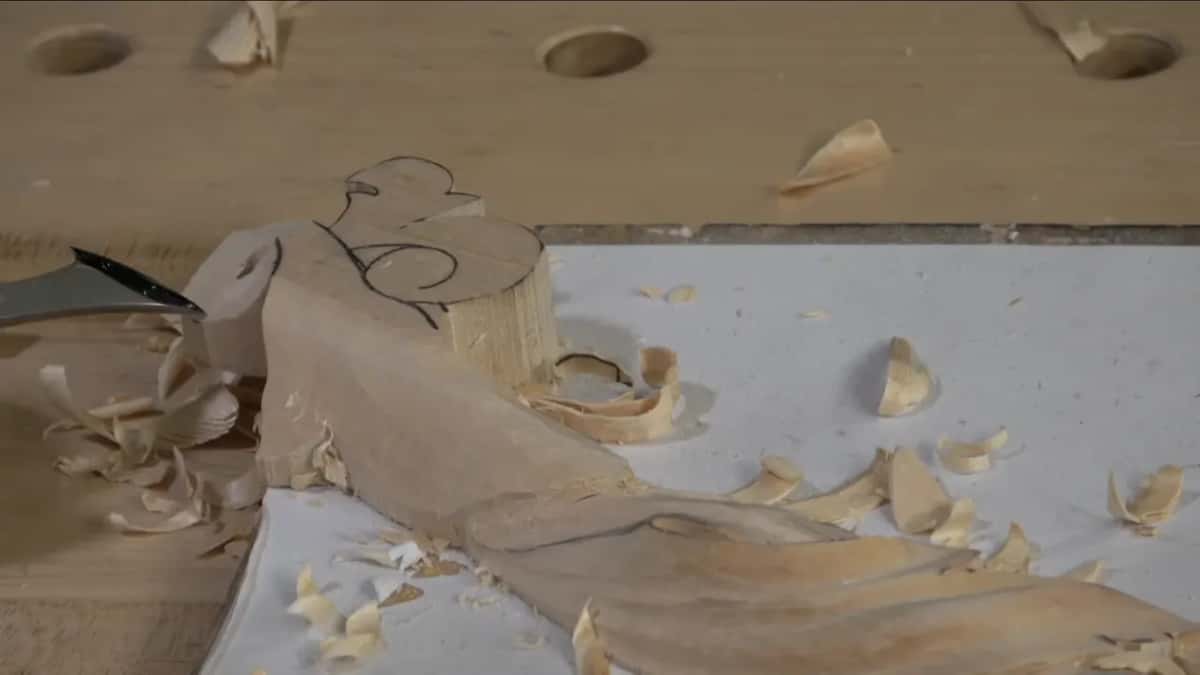 Shavings piled against the carved volute.